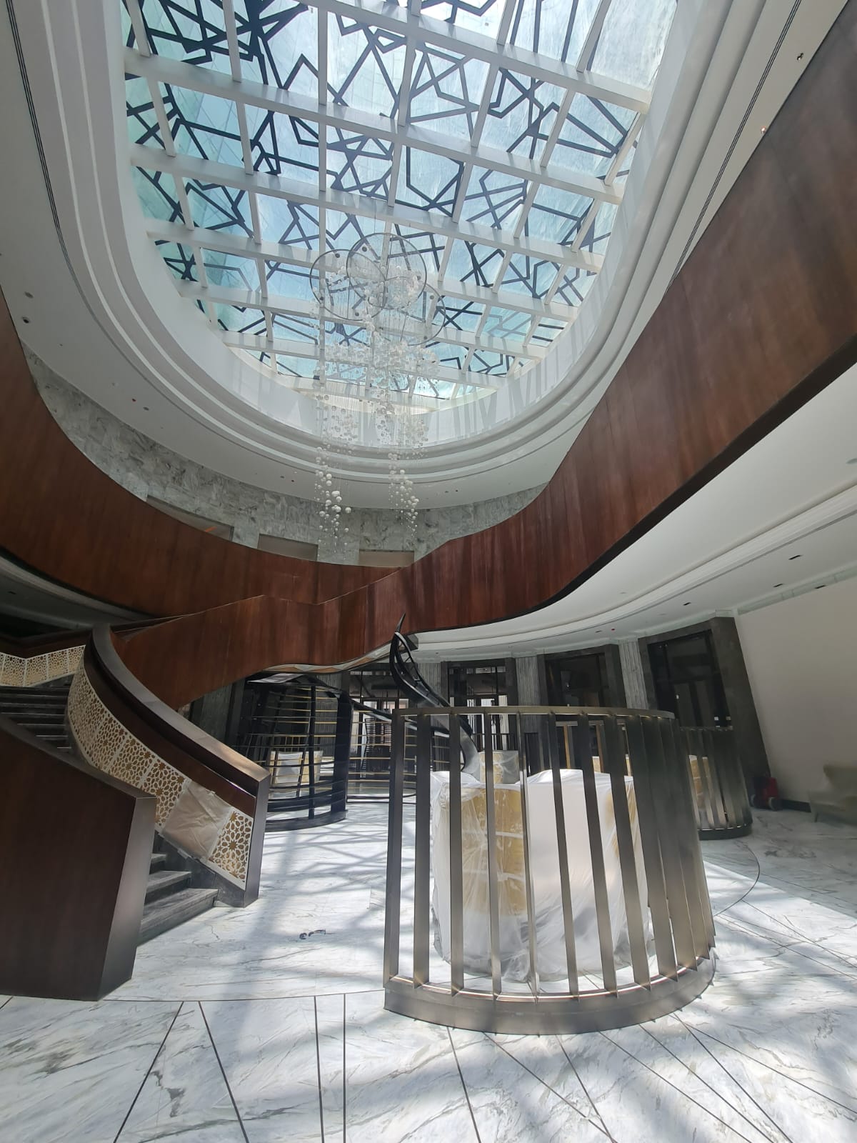 Atrium stair, skylight, chandelier, and curved wood finish