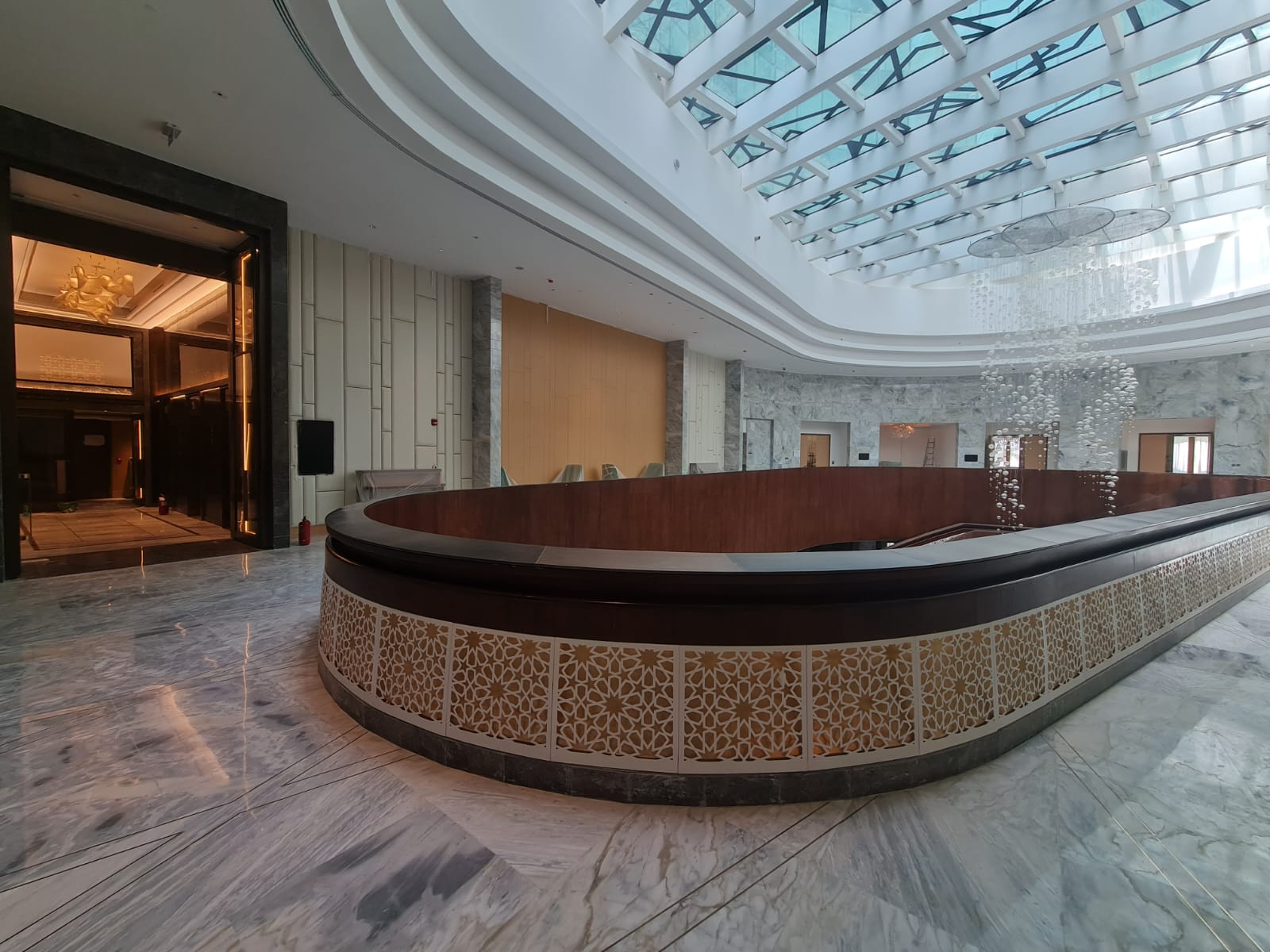 Curved balcony rail with patterned panels and marble floor