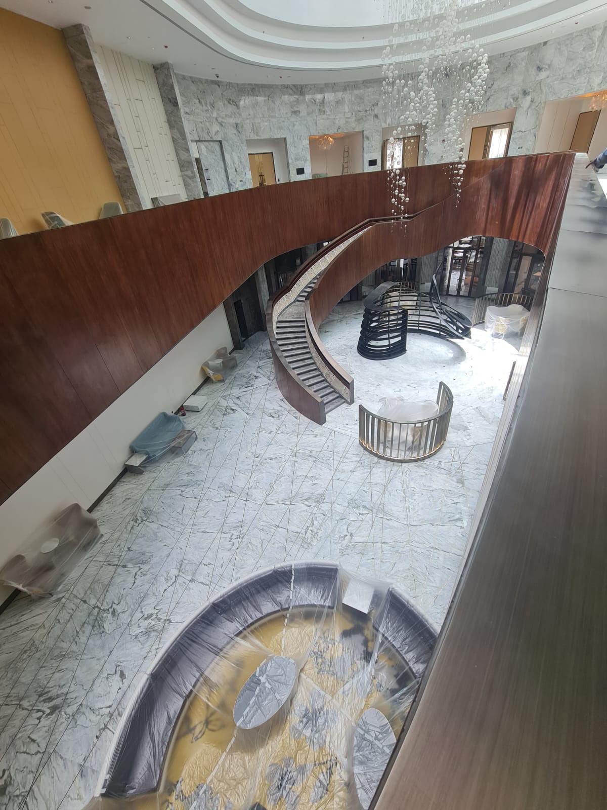 Overhead view of curved timber balustrade and marble floor