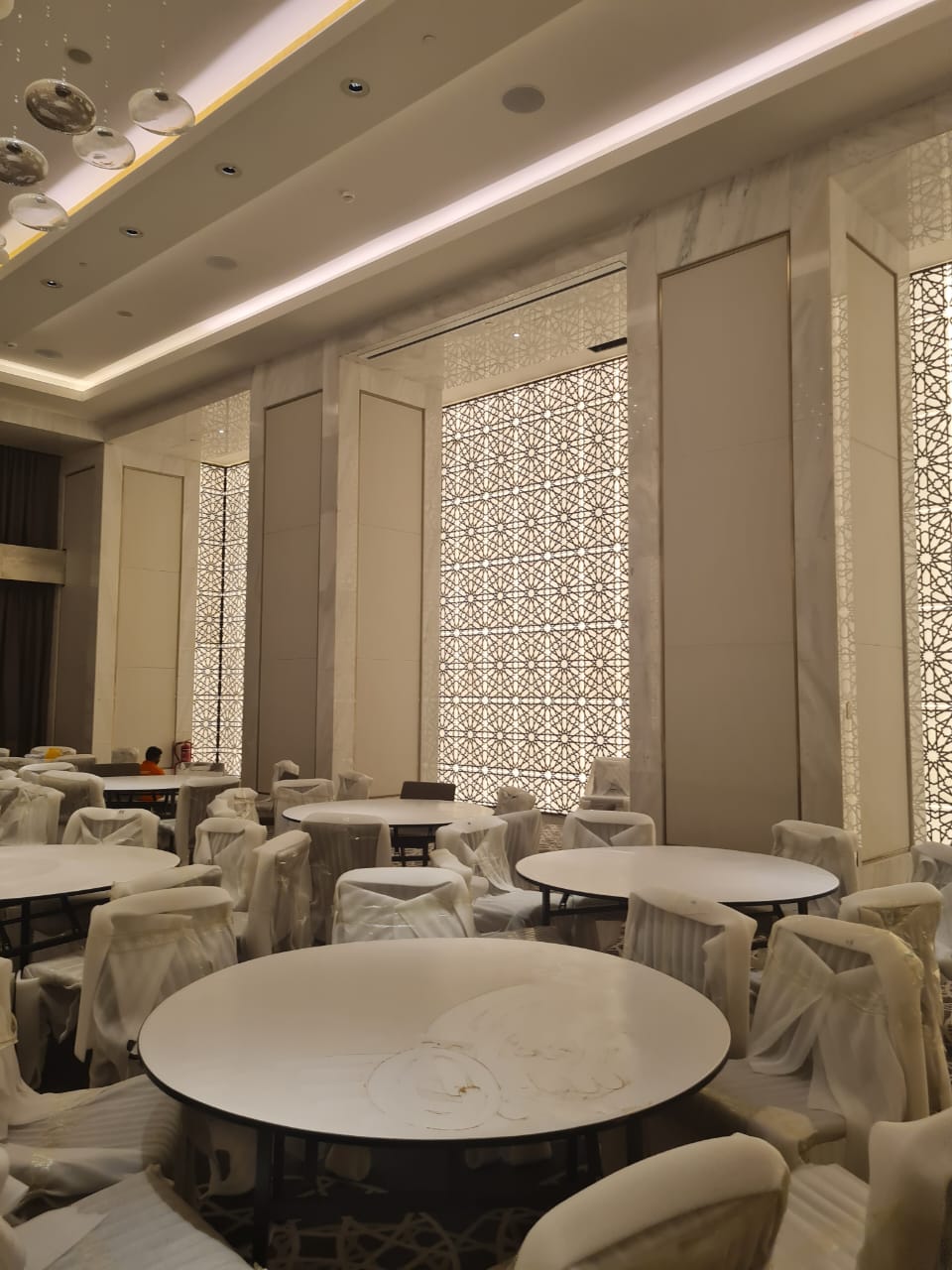 Dining room with luminous patterned screens and protected furniture
